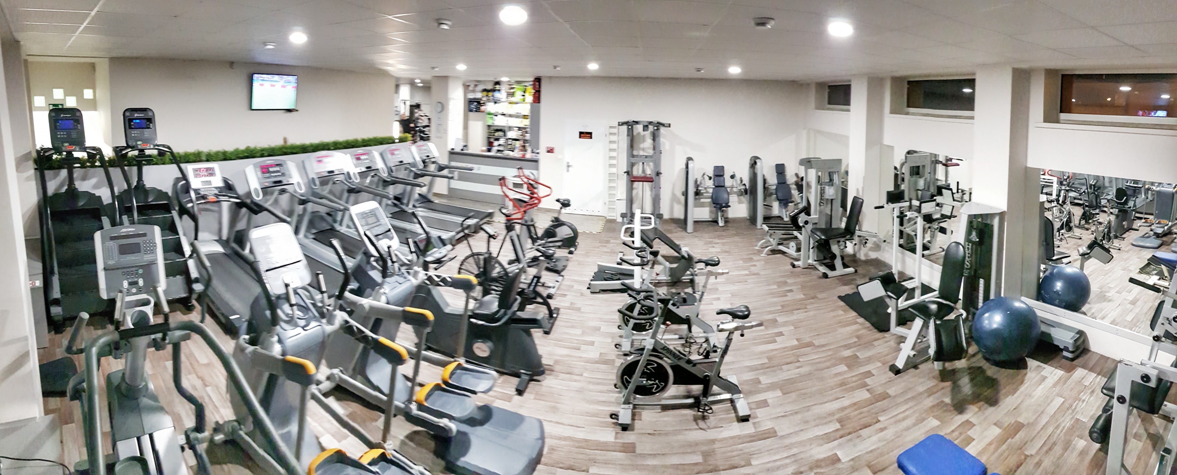 Hala cardio w Body Center, rzędy bieżni, orbitreków i rowerków na drewnianej podłodze