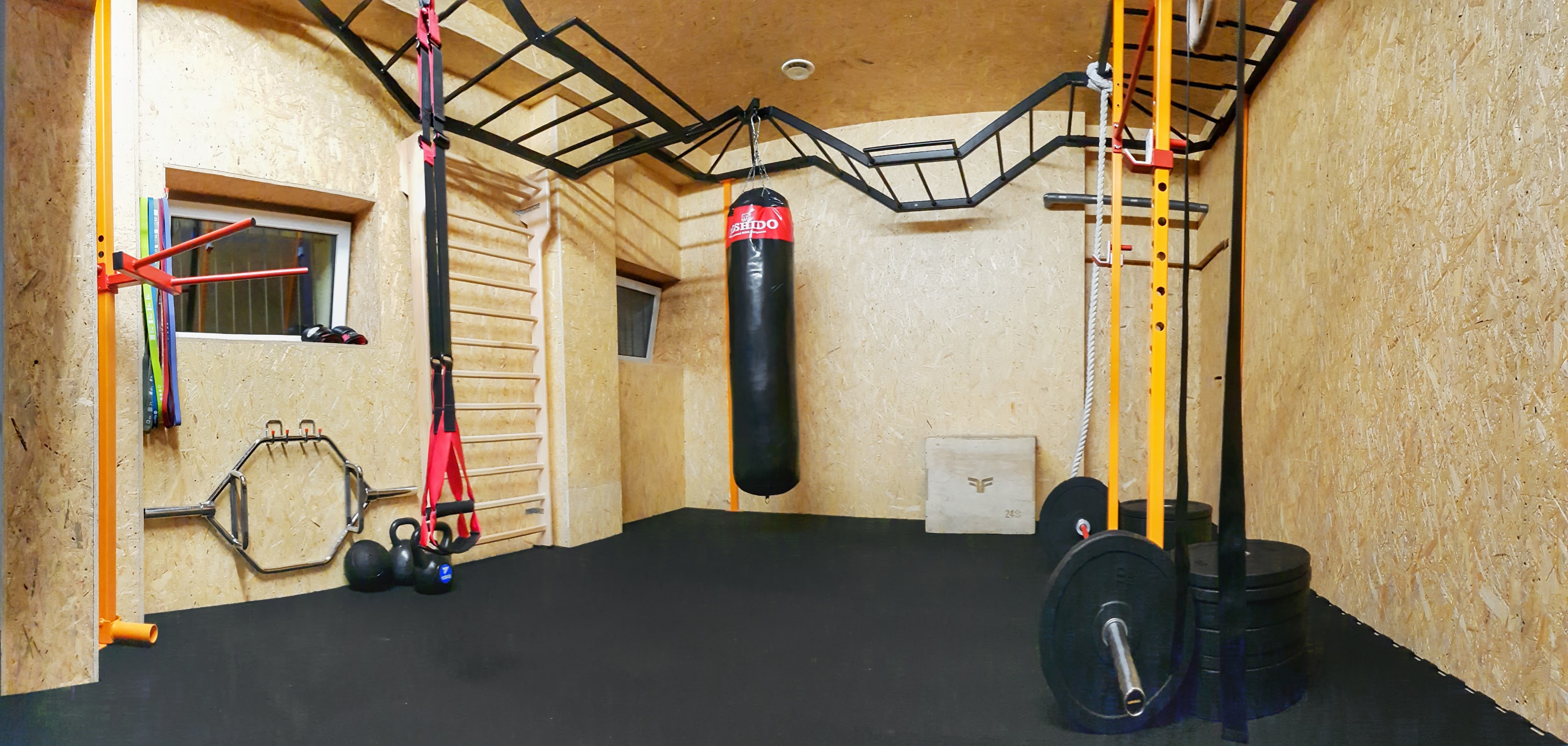 Strefa functional Body Center w Łasku, worek bokserski Krido, drabinka, OSB na ścianach, czarna guma na podłodze, żółte stojaki